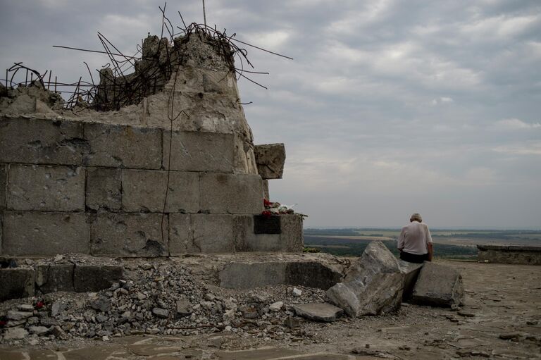 Мужчина у мемориала на кургане Саур-Могила в Донецкой области