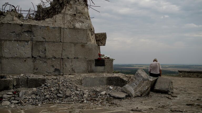 Мужчина у мемориала на кургане Саур-Могила в Донецкой области