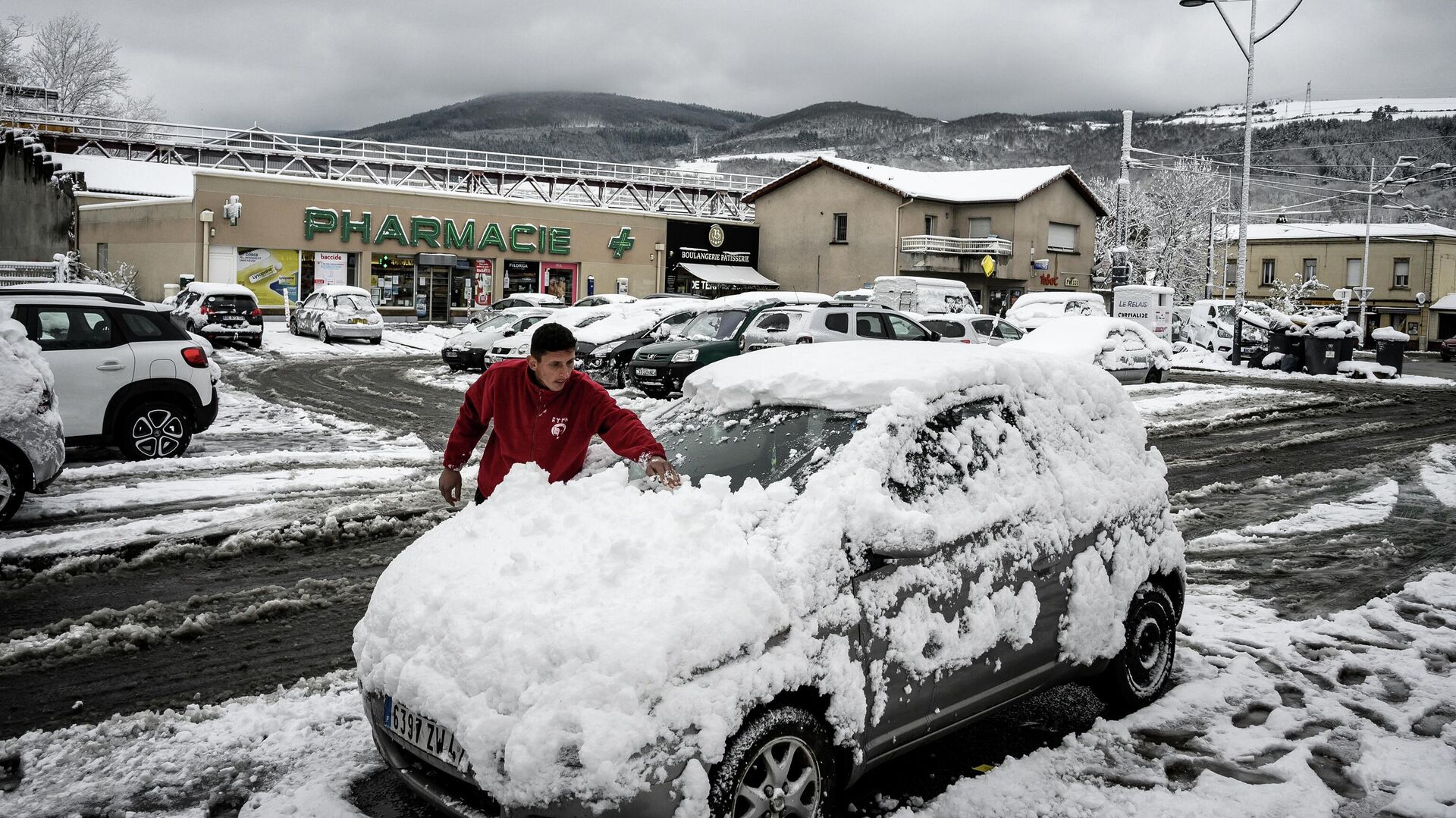 Мужчина чистит свой автомобиль после апрельского снегопада в Сент-Этьене, Франция  - РИА Новости, 1920, 06.04.2022