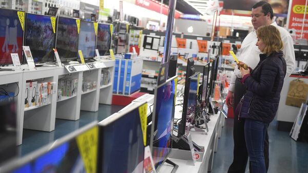 Посетители рассматривают телевизоры в магазине по продаже цифровой и бытовой техники
