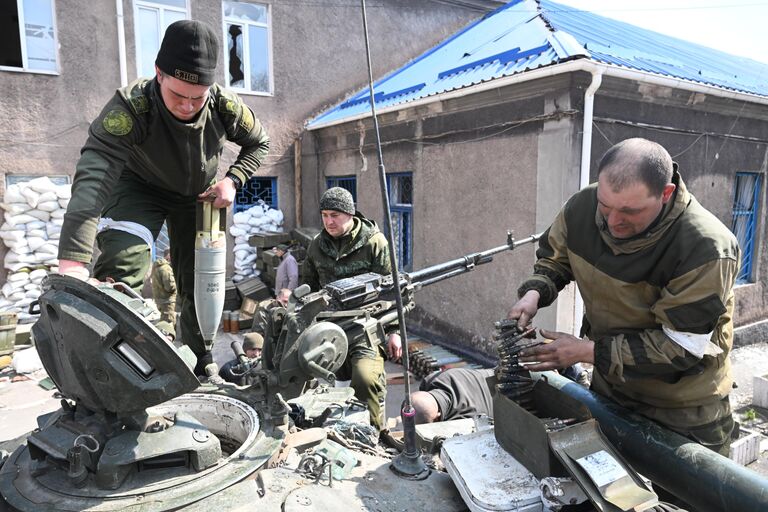 Танкисты Народной милиции ДНР снаряжают боеприпасами танк Т-72 на одной из улиц Мариуполя