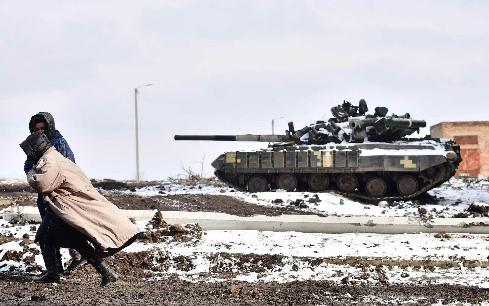 Жители Волновахи идут по дороге мимо подбитого танка Вооруженных сил Украины - РИА Новости, 1920, 11.04.2022