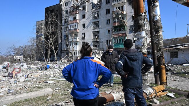 Люди во дворе дома в Левобережном районе Мариуполя