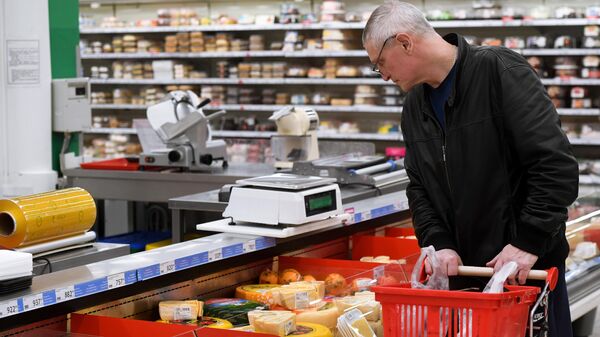 Покупатель в отделе сыров супермаркета Ашан Сити 