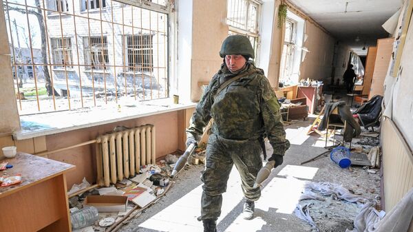 Саперы Вооруженных сил РФ выносят боеприпасы из здания в Левобережном районе Мариуполя, где была оборудована позиция ВСУ