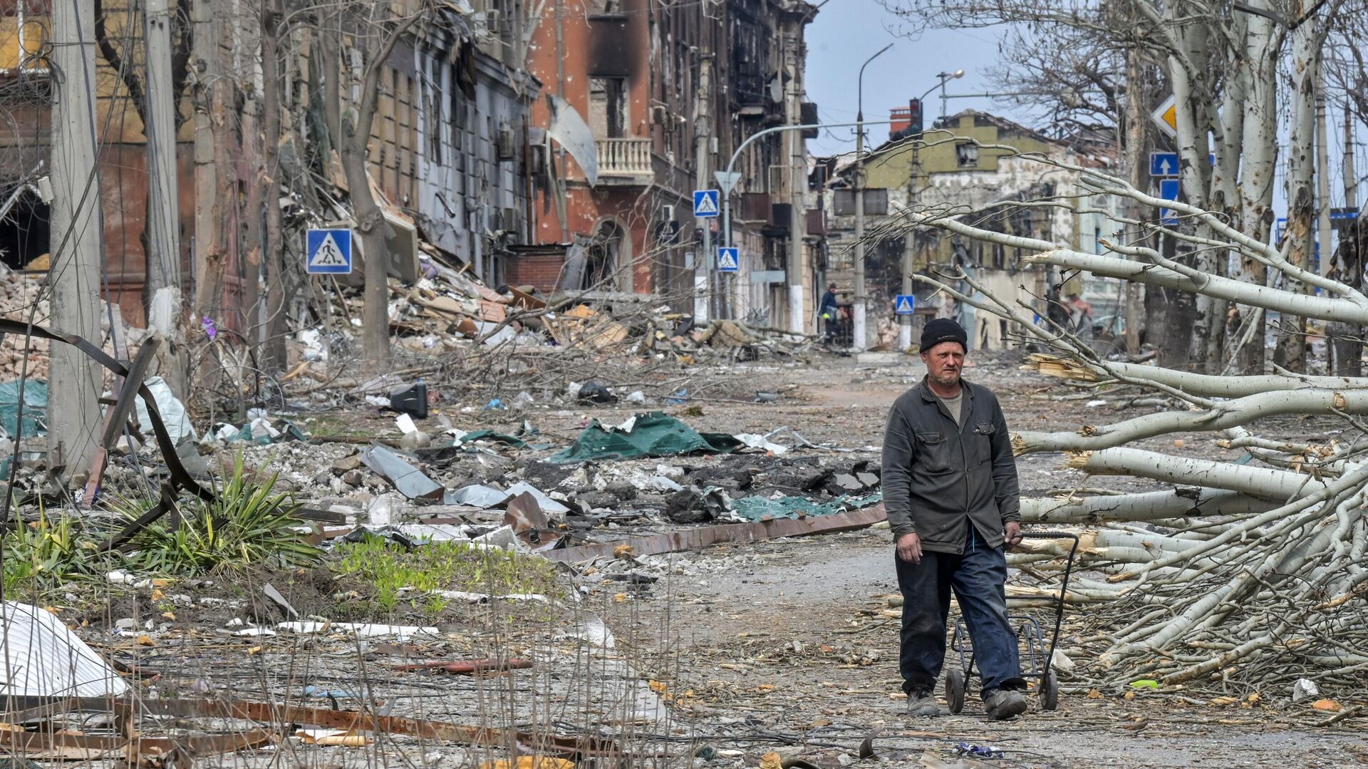 Житель Мариуполя у разрушенных зданий на улице города - РИА Новости, 1920, 20.04.2023