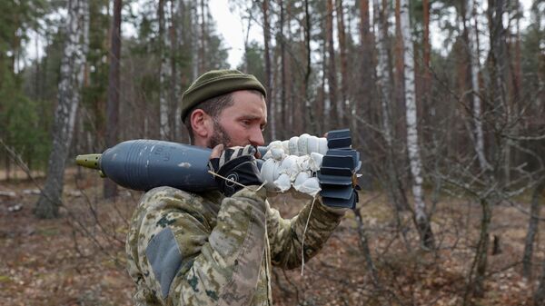 Военнослужащий ВСУ со снарядом для миномета в Киевской области