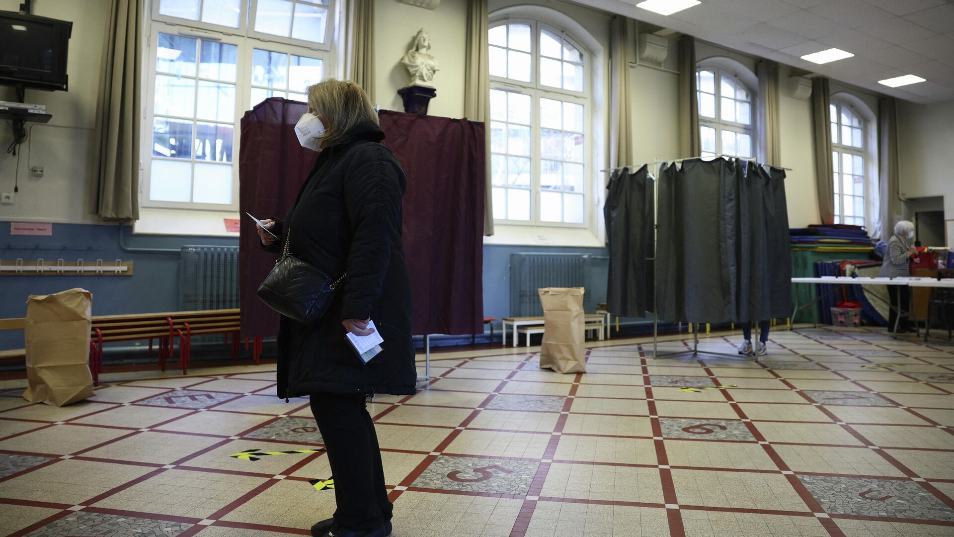 Женщина держит бюллетень для голосования в первом туре президентских выборов во Франции на избирательном участке в Париже - РИА Новости, 1920, 10.04.2022