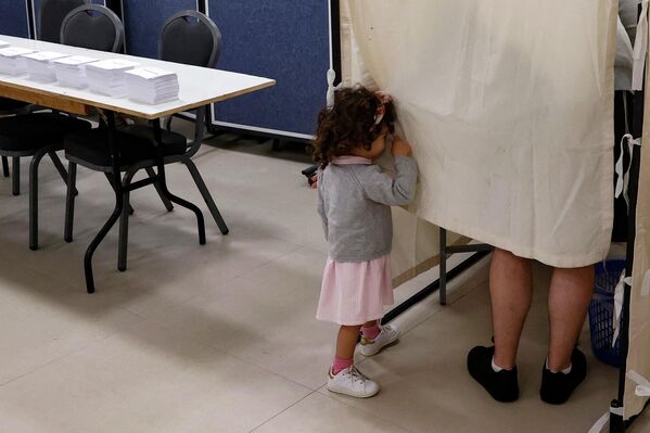 Ребенок на избирательном участке в израильском Тель-Авиве во время голосования в первом туре выборов президента Франции 