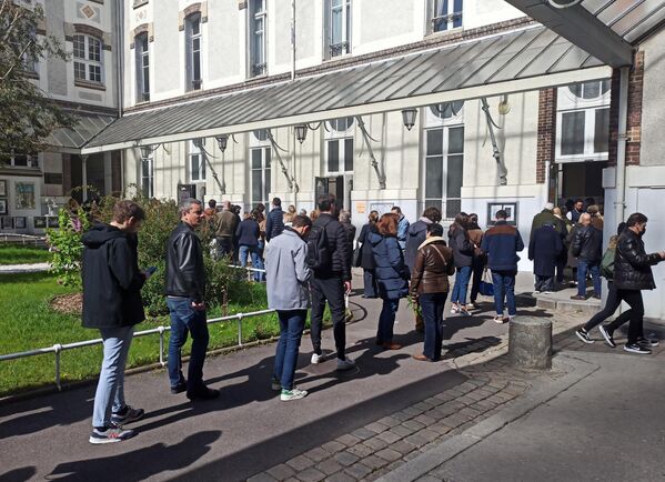 Люди стоят в очереди на избирательный участок в Париже
