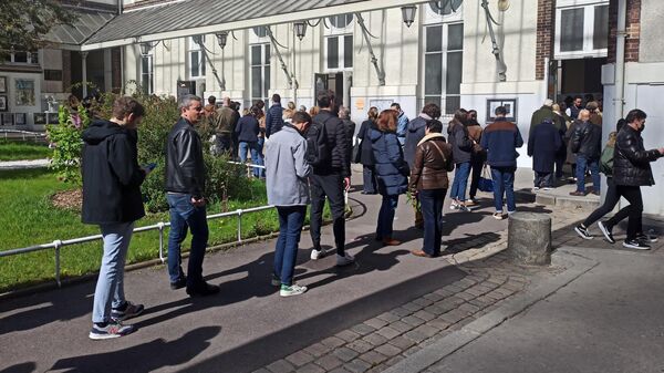 Люди стоят в очереди на избирательный участок в Париже