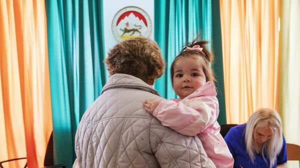 Женщина с ребенком на выборах главы республики Южная Осетия на избирательном участке №23 в Цхинвале