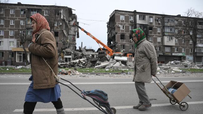 Жители Мариуполя идут по улице города