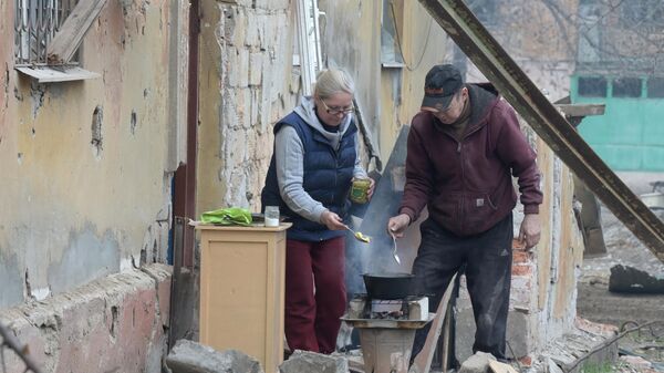 Жители Левобережного района Мариуполя готовят еду на костре возле подъезда дома