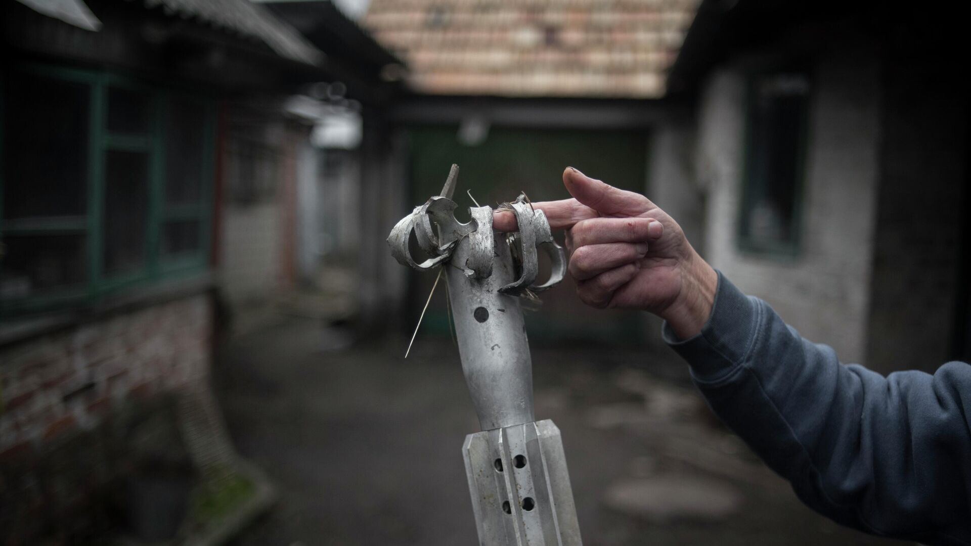 Женщина демонстрирует осколок мины во дворе жилого дома - РИА Новости, 1920, 23.04.2022