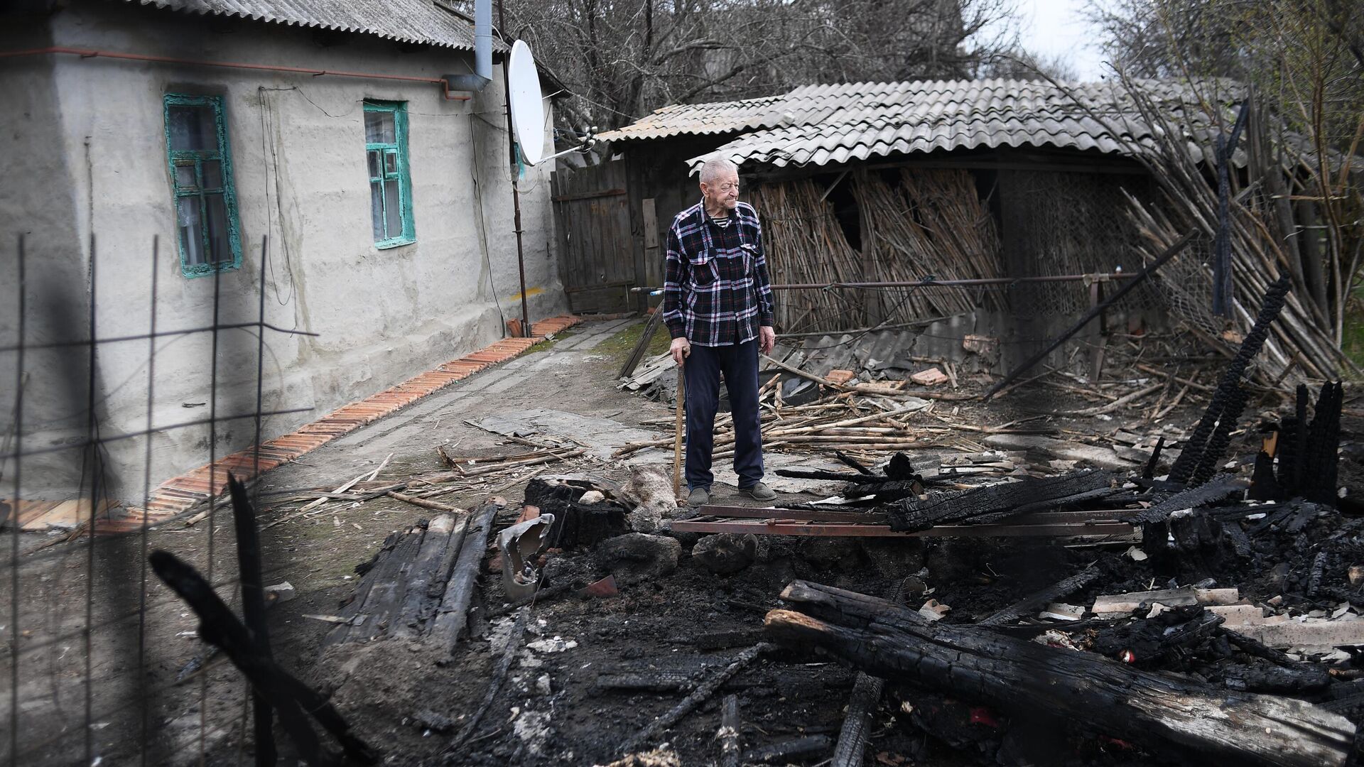 Мужчина во дворе жилого дома, пострадавшего в результате обстрела, в ЛНР - РИА Новости, 1920, 20.04.2022