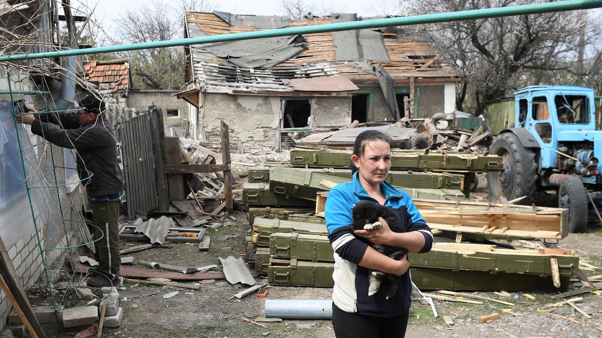 Женщина во дворе жилого дома, пострадавшего в результате обстрела, в населенном пункте Фрунзе в ЛНР - РИА Новости, 1920, 15.04.2022