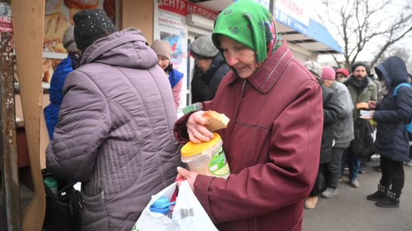 Местная жительница в очереди за горячей едой в центре гуманитарной помощи в Мариуполе