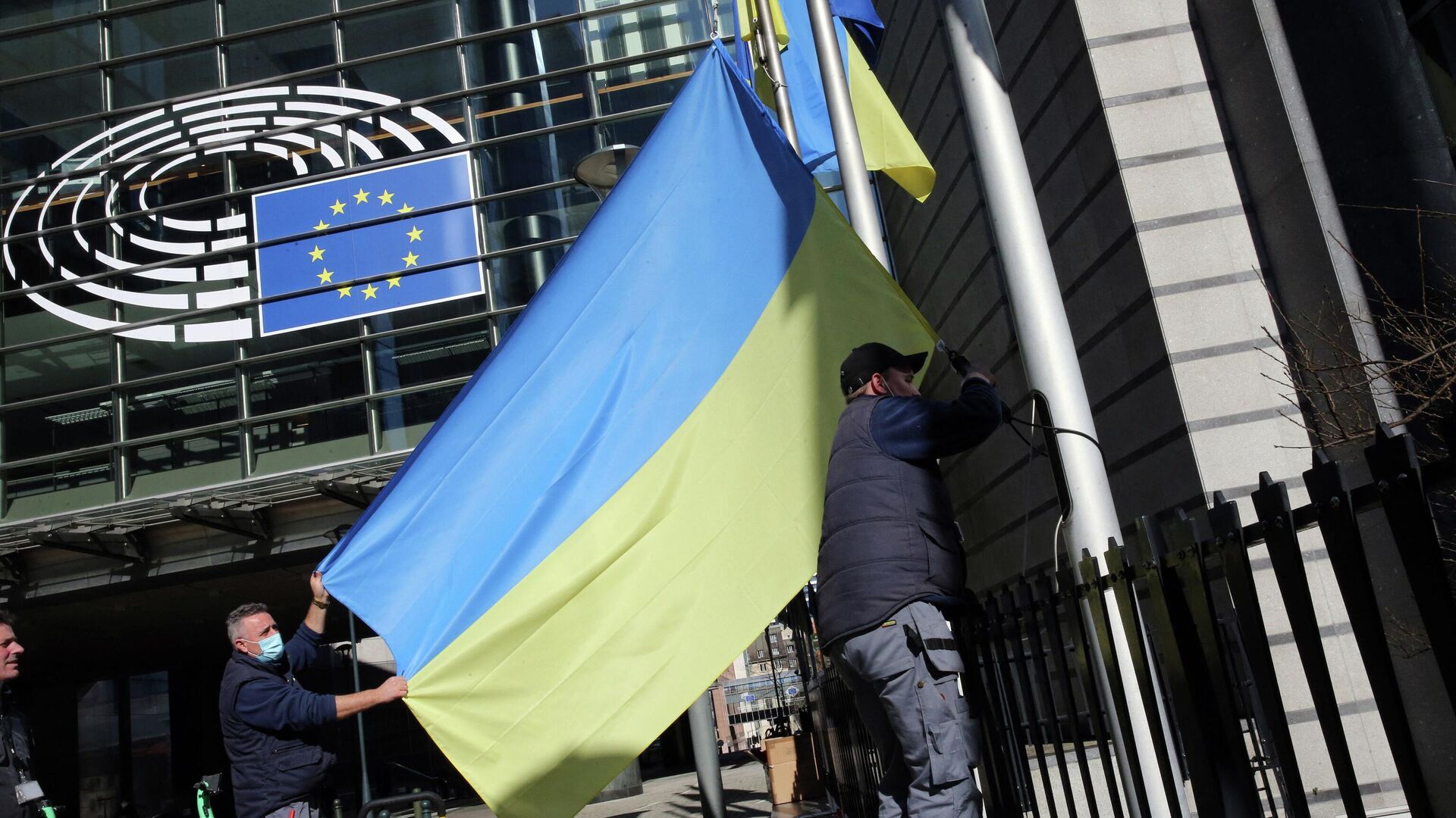 Рабочие устанавливают флаг Украины возле здания Европейского парламента в Брюсселе - РИА Новости, 1920, 15.04.2022