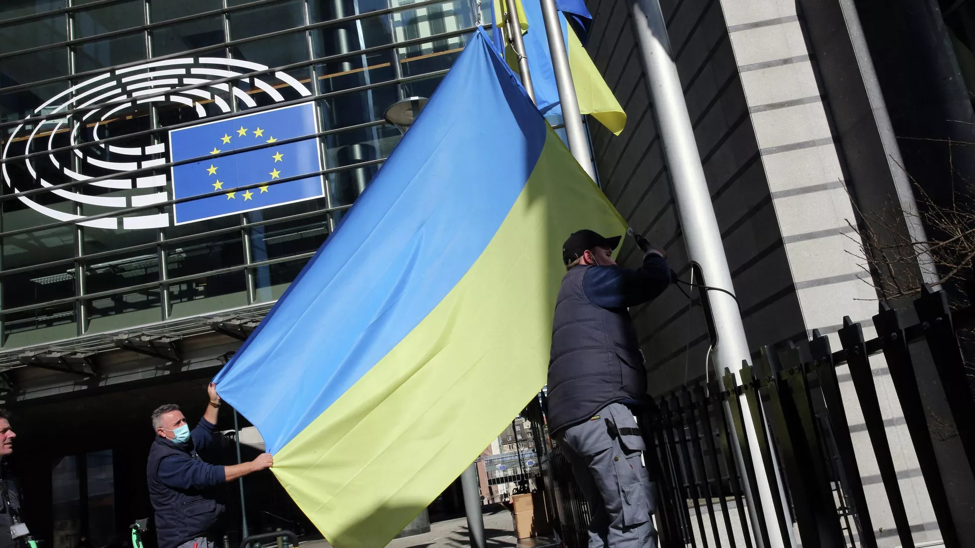 Οι εργαζόμενοι εγκαθιστούν τη σημαία της Ουκρανίας κοντά στο κτίριο του Ευρωπαϊκού Κοινοβουλίου στις Βρυξέλλες - RIA Novosti, 1920, 15/04/2022