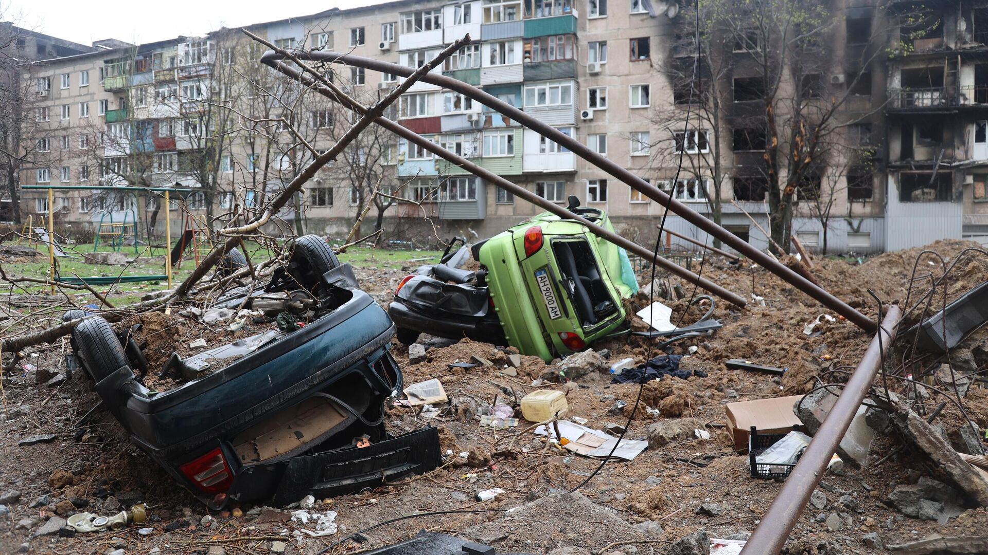 Разбитые автомобили во дворе одного из жилых домов в Мариуполе - РИА Новости, 1920, 15.04.2022