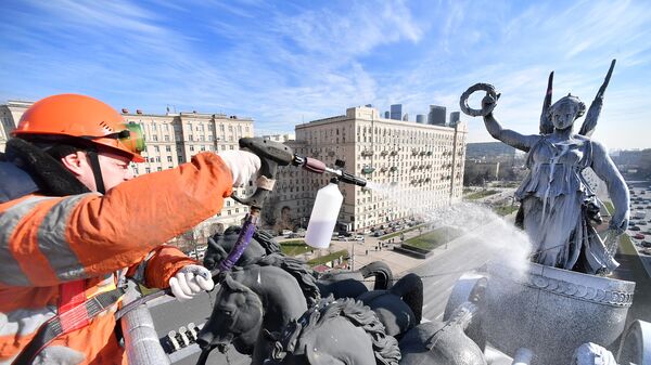 Сотрудник Гормост производит весеннюю помывку Триумфальной арки на Кутузовском проспекте в Москве