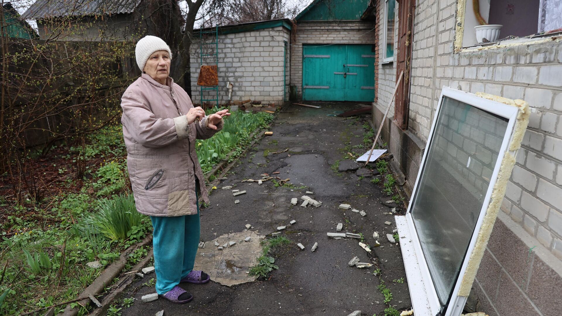 Женщина показывает свой дом, обстрелянный ВСУ - РИА Новости, 1920, 11.06.2022