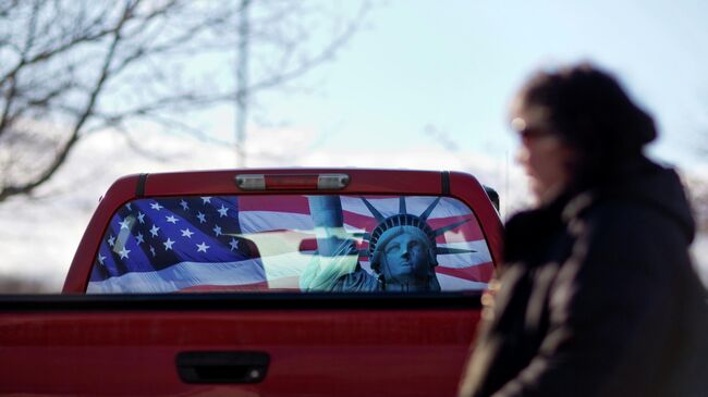 Изображение флага США и статуи Свободы на заднем стекле автомобиля в Манчестере 