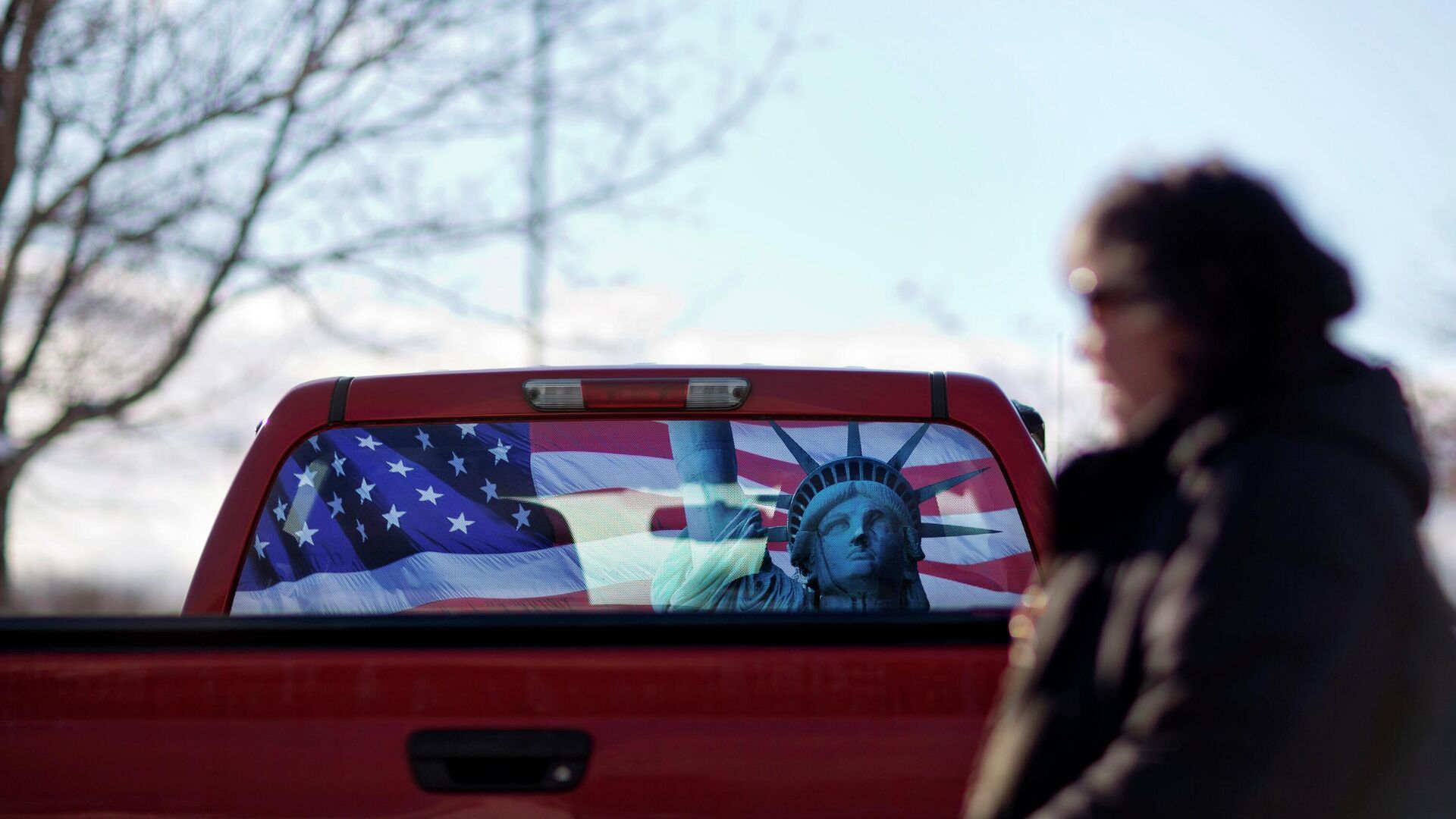 Изображение флага США и статуи Свободы на заднем стекле автомобиля в Манчестере  - РИА Новости, 1920, 30.12.2022