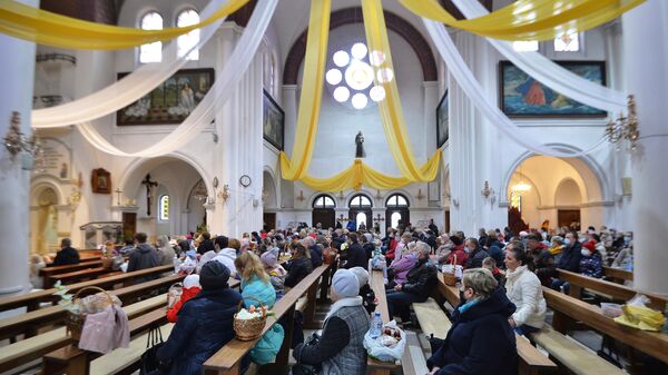 Прихожане освящают пасхальные продукты в канун католической Пасхи в костёле святого Симона и святой Елены в Минске