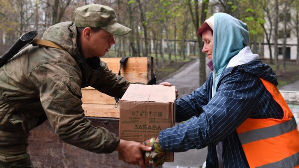 Боец НМ ЛНР во время раздачи гуманитарной помощи местным жителям в Купянске