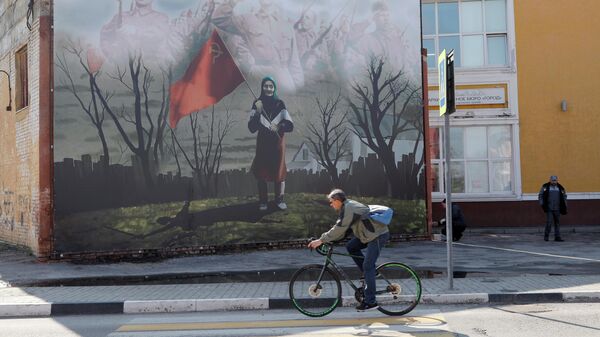 Баннер с изображением бабушки с красным флагом на торце здания в городе Шебекино Белгородской области