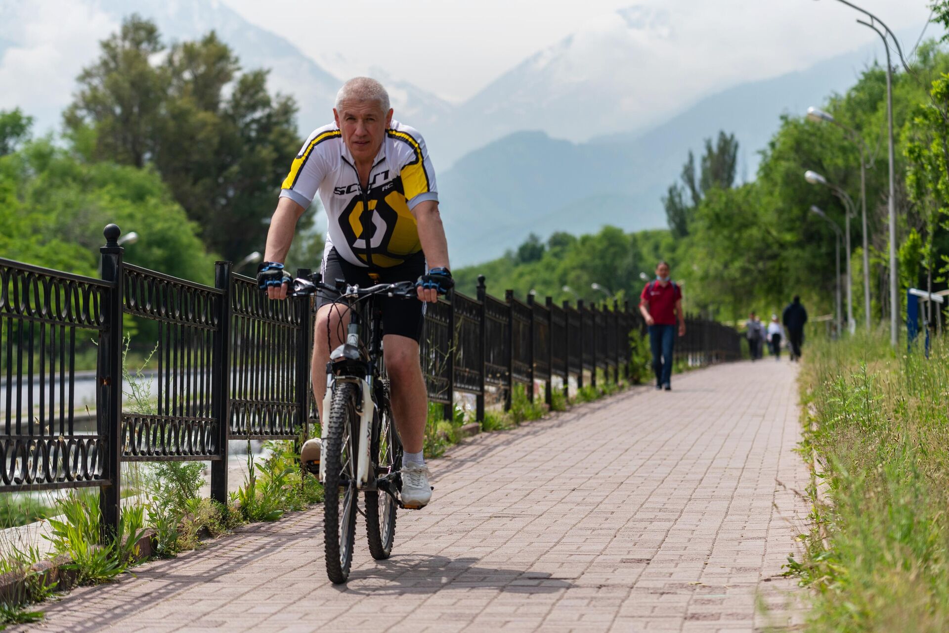 Мужчина на велосипеде в одном из парков в Алма-Ате - РИА Новости, 1920, 26.07.2022