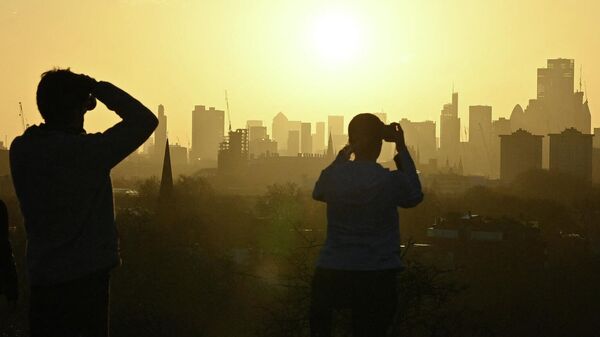 Люди фотографируют закат в Лондоне 