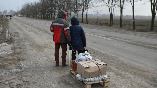 Жители идут по дороге на окраине Мариупол