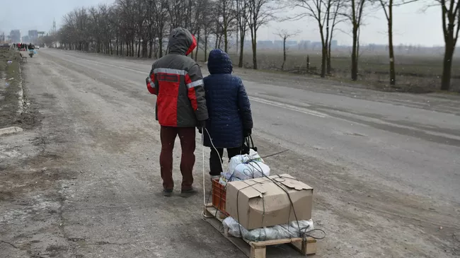 Жители идут по дороге на окраине Мариупол
