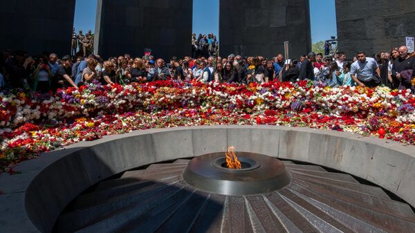 Люди на торжественной церемонии возложения венков и цветов к мемориалу жертв геноцида армян Цицернакаберд в Ереване