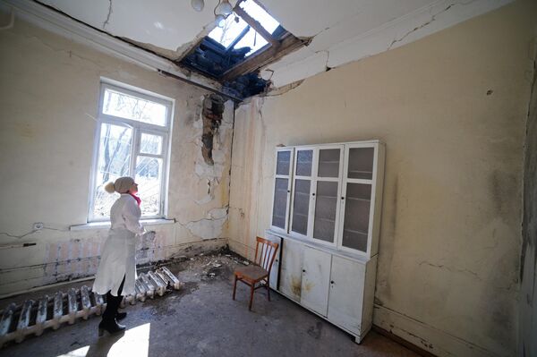 Сотрудница осматривает повреждения после обстрела в городской больнице № 20 в Донецке, 2015 год.