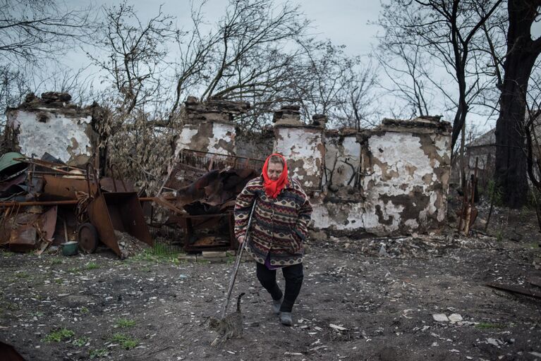 Женщина у разрушенного дома в поселке Саханка Донецкой области