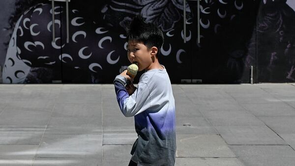 Ребенок ест мороженое возле торгового центра в Пекине