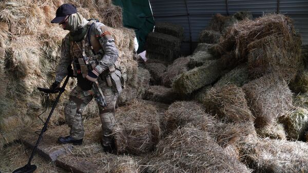 Российский боец обследует территорию в районе, где был обнаружен схрон с оружием
