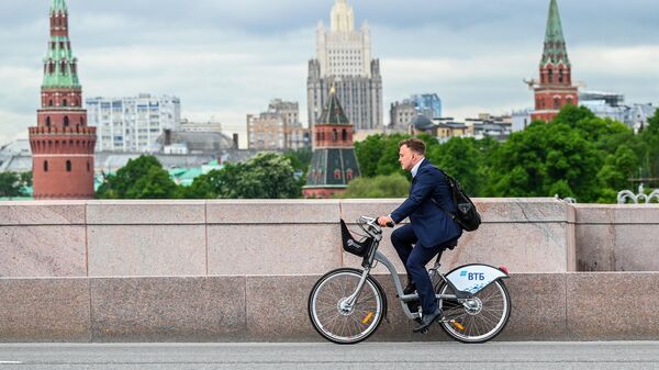 Мужчина едет на велосипеде на Большом Москворецком мосту в Москве