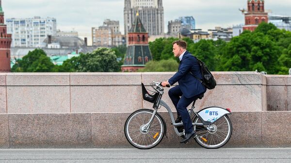 Мужчина едет на велосипеде на Большом Москворецком мосту в Москве