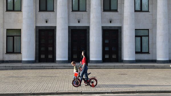 Женщина с ребенком у административного здания в Луганске.