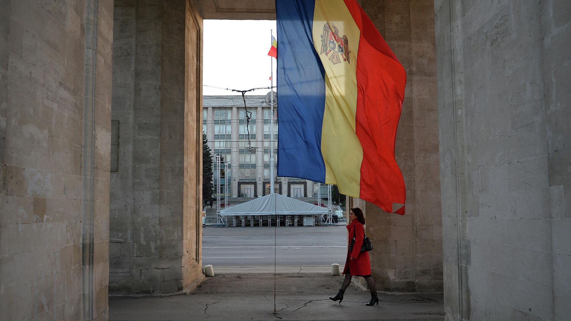 Девушка идет под триумфальной аркой рядом с флагом Молдавии в Кишиневе - РИА Новости, 1920, 29.04.2022