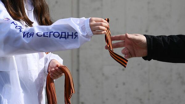 Волонтер раздает георгиевские ленточки на Зубовском бульваре в Москве в рамках ежегодной акции Георгиевская ленточка