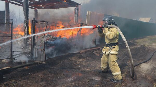 Сотрудник МЧС во время ликвидации пожара в Кургане