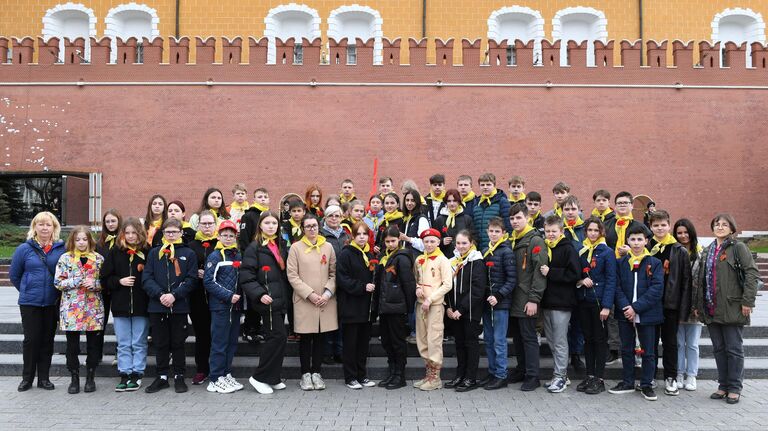 Учащиеся средней общеобразовательной школы №11 городского округа Балашиха фотографируются у Могилы Неизвестного Солдата в Александровском саду в Москве во время ежегодной акции Георгиевская ленточка