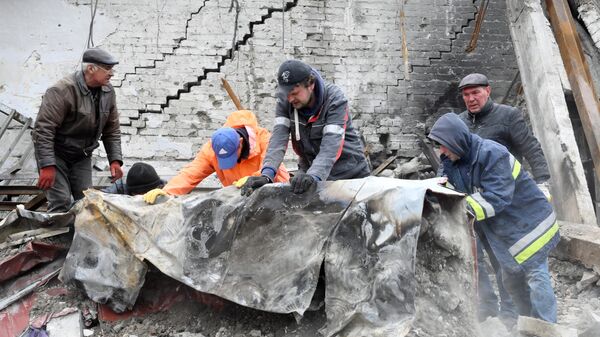 Сотрудники МЧС ДНР разбирают завалы на месте разрушенного Донецкого академического областного драматического театра в Мариуполе
