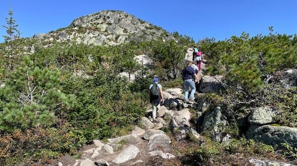 Туристы поднимаются к Висячему камню в природном парке Ергаки